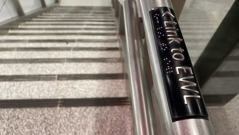 Metallic railing with 'Link to EWL' branding on a staircase.