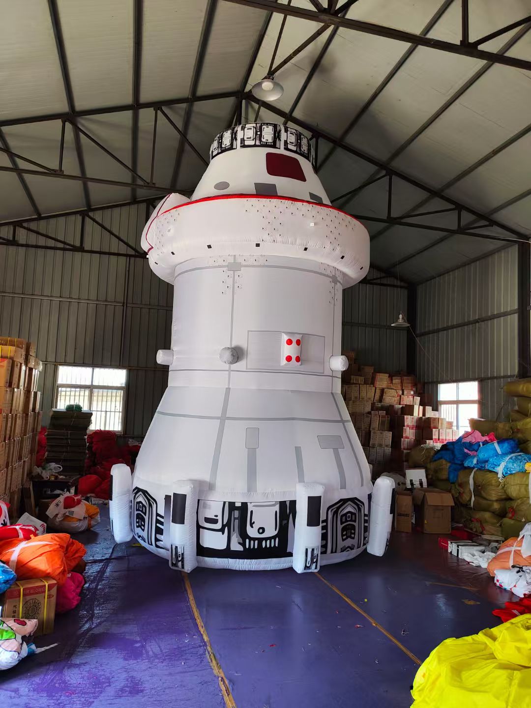 Inflatable model of a space station or rocket in a warehouse setting
